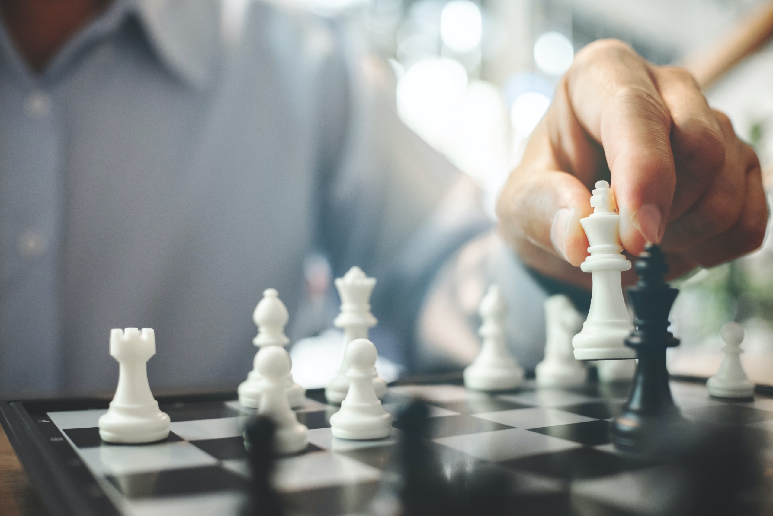 Hand of businessman playing chess game,competition success play,management or leadership concept.