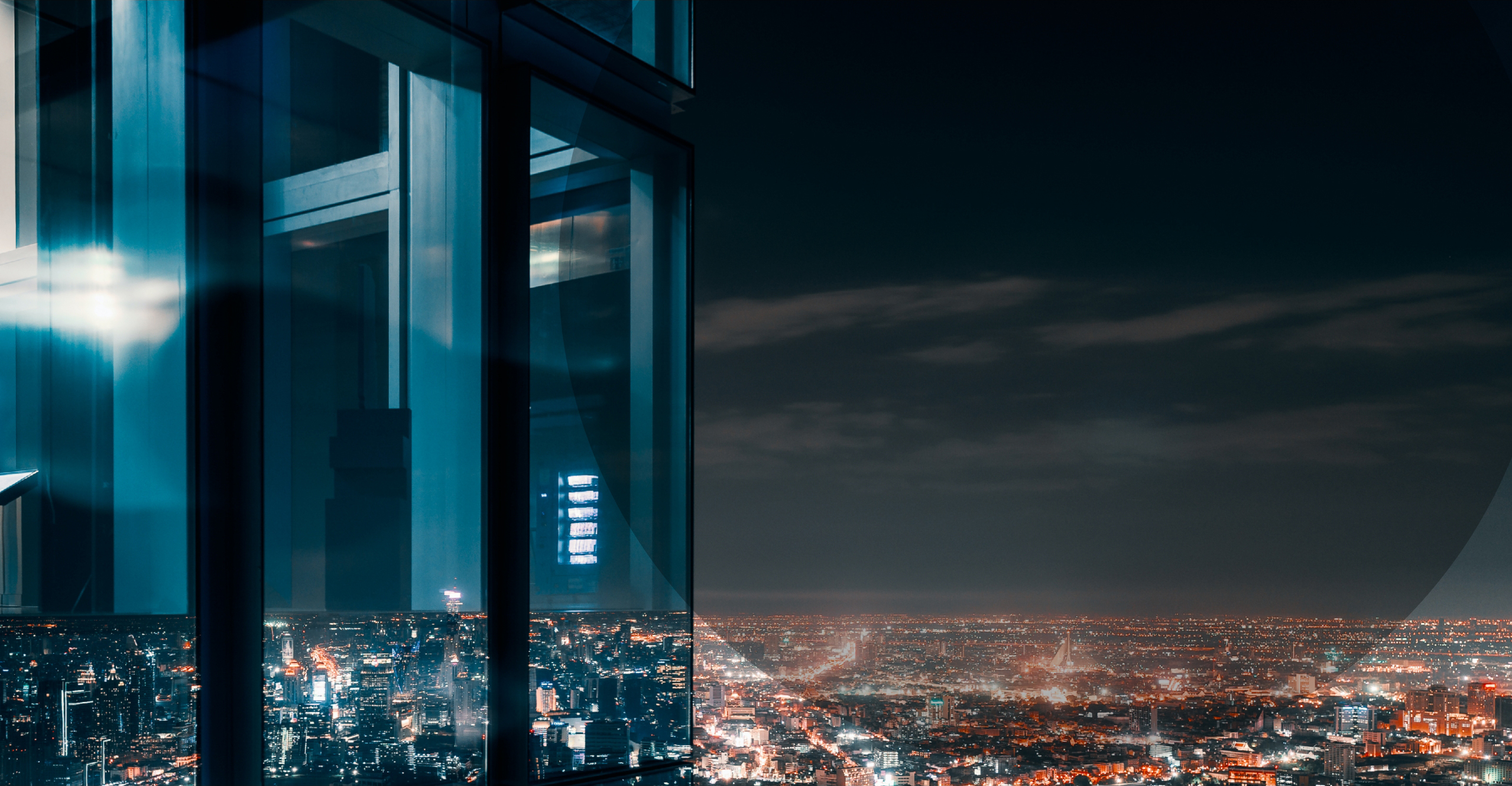 Corner glass window with glowing crowded city