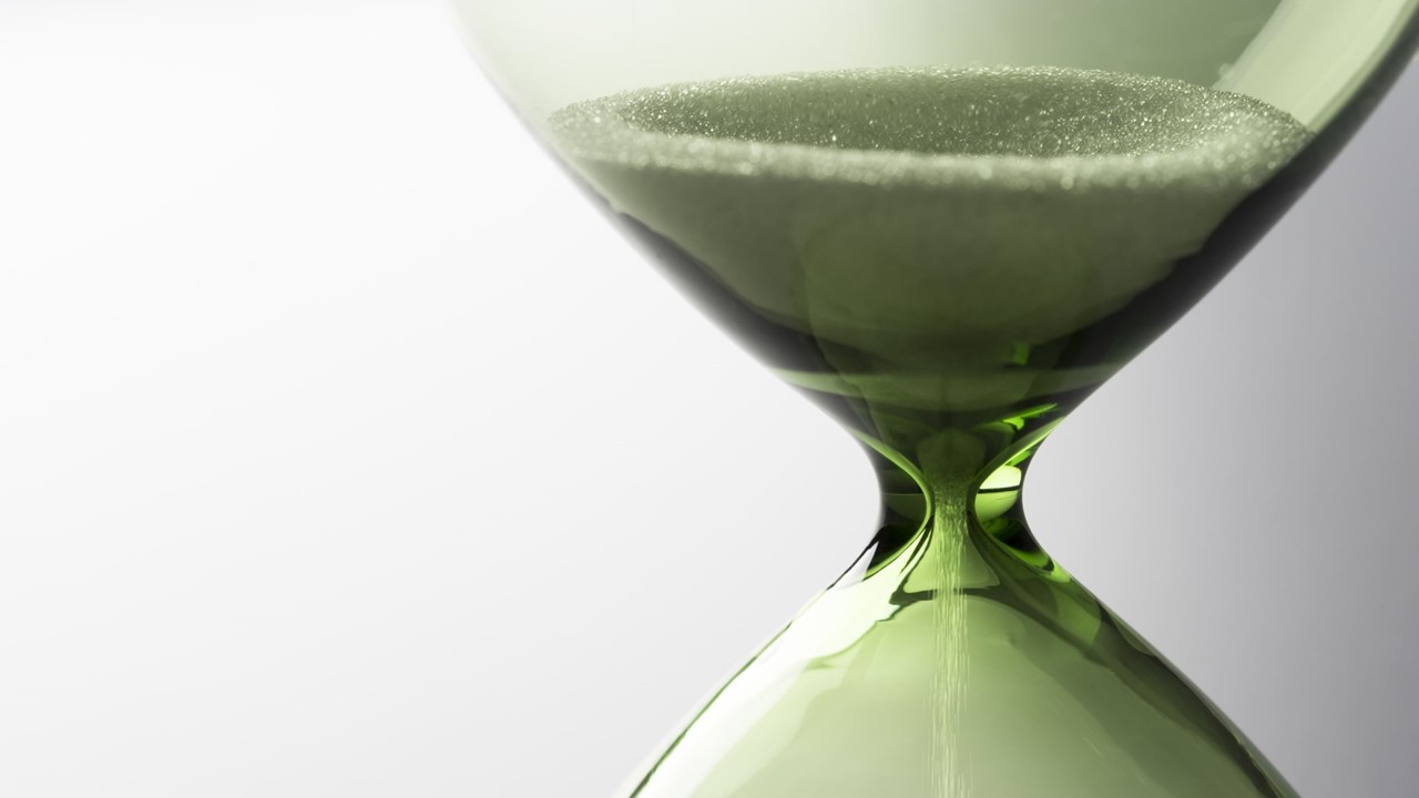 Close up of green sand in a hourglass.