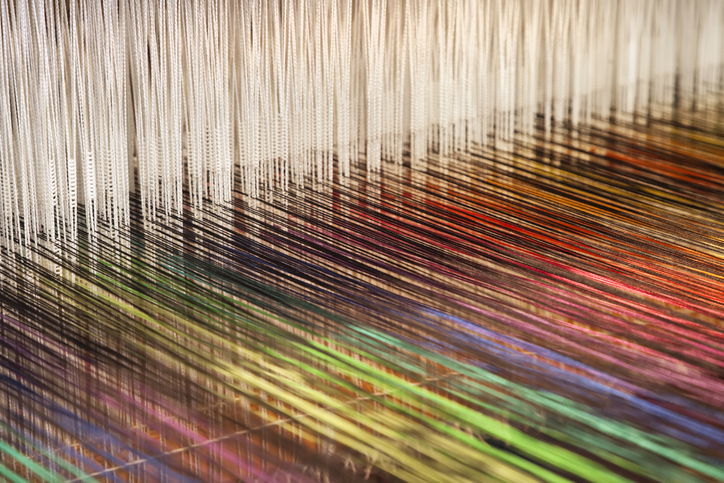 Close-up of a loom weaving colorful fabric