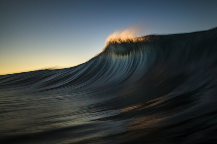 FINRA risk assessment - Dark majestic wave cresting in golden morning light
