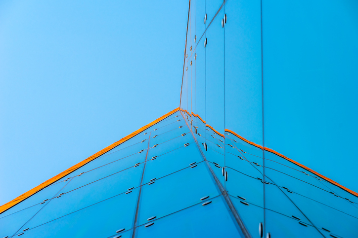 An modern architecture detail with glass structure. This picture was taken on the outer side of an entrance area of a modern office building in the "Hamburg HafenCity". It was taken from the sidewalk upwards into the ceiling of the outer entrance area. It was taken on the open air and free accessible entrance area. In post process the picture is blue and orange toned for a bright and clean look.