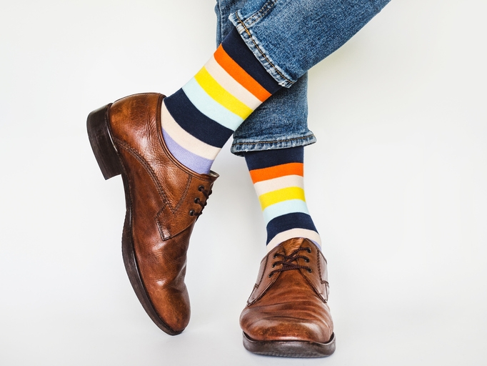 Men's legs, trendy shoes and bright socks. Close-up. Style, beauty and elegance concept